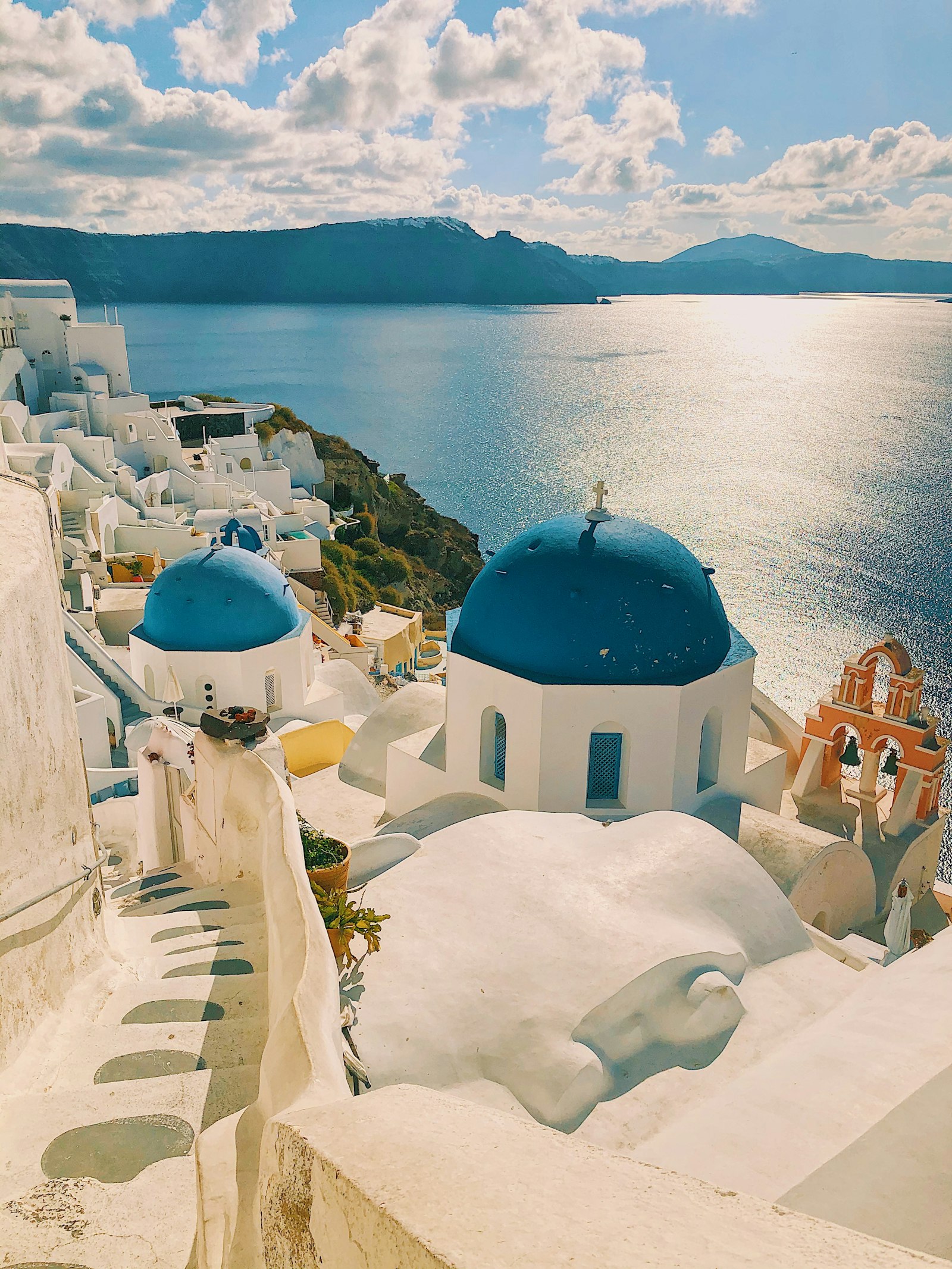 Whitewashed luxury suite with private plunge pool overlooking the Santorini caldera at sunset