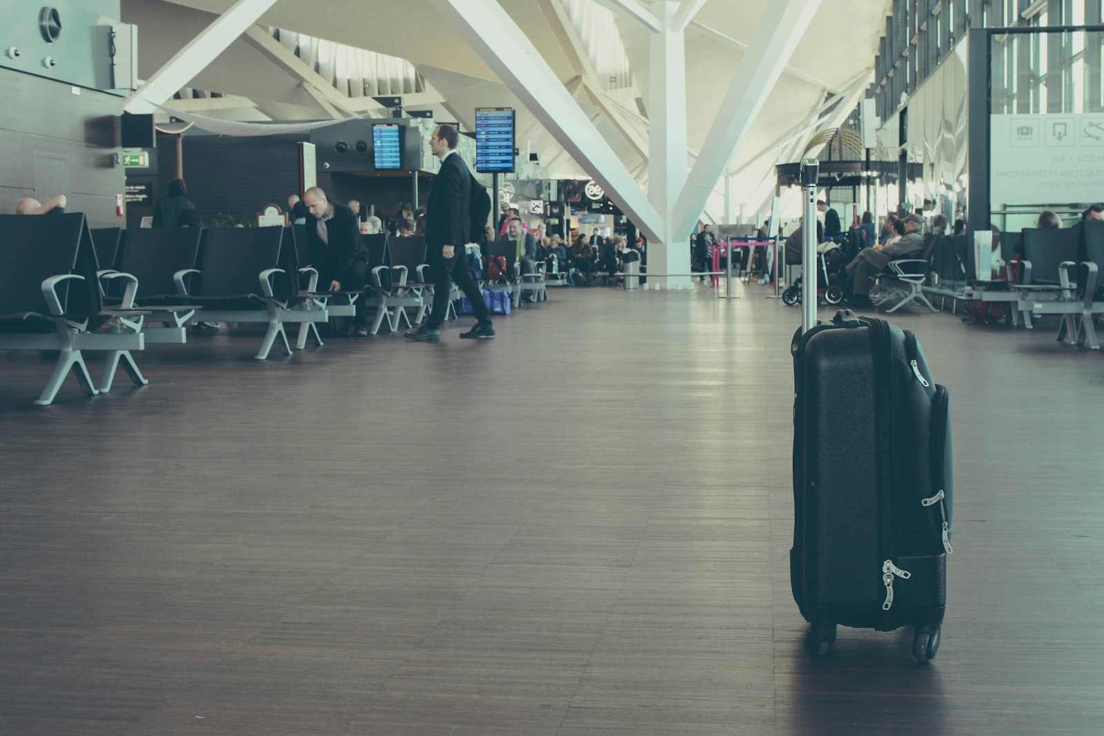 Suitcase standing in an airport terminal by the departures windows