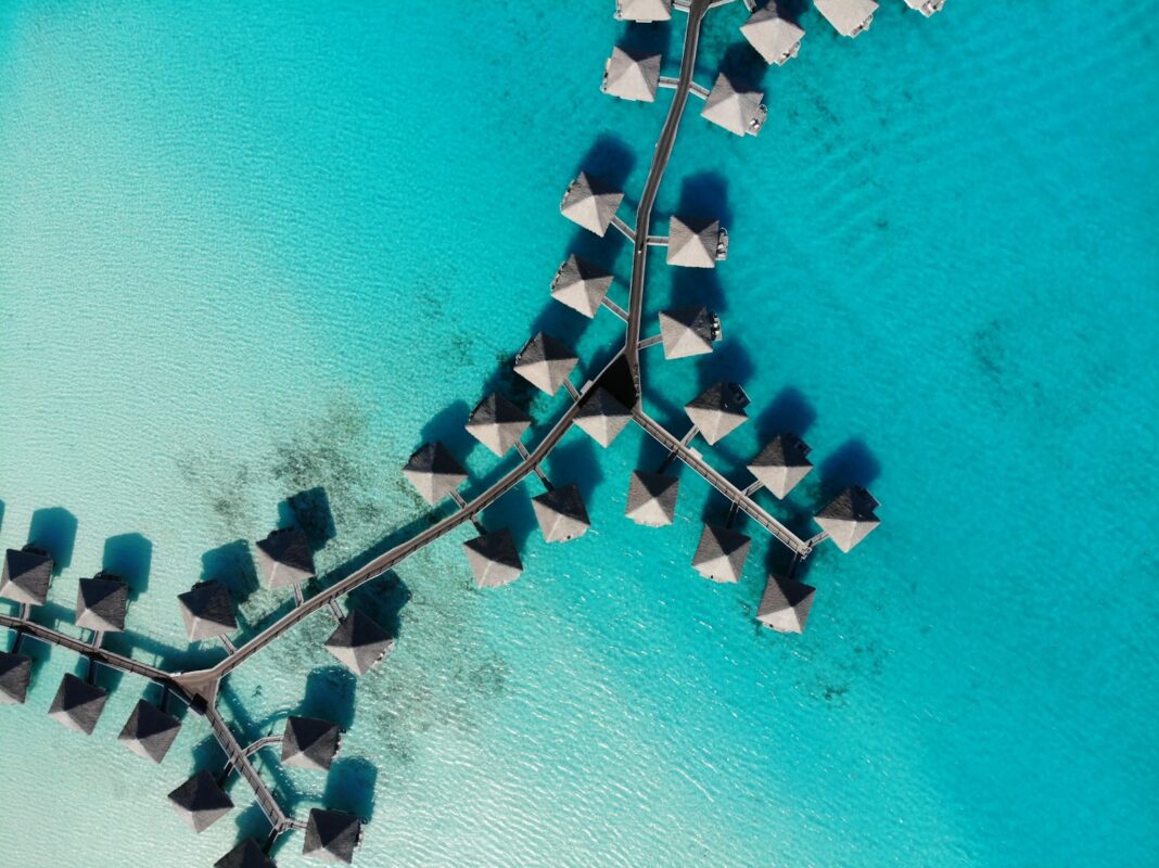 Overwater bungalows over turquoise lagoon — Bora Bora vs Maldives comparison