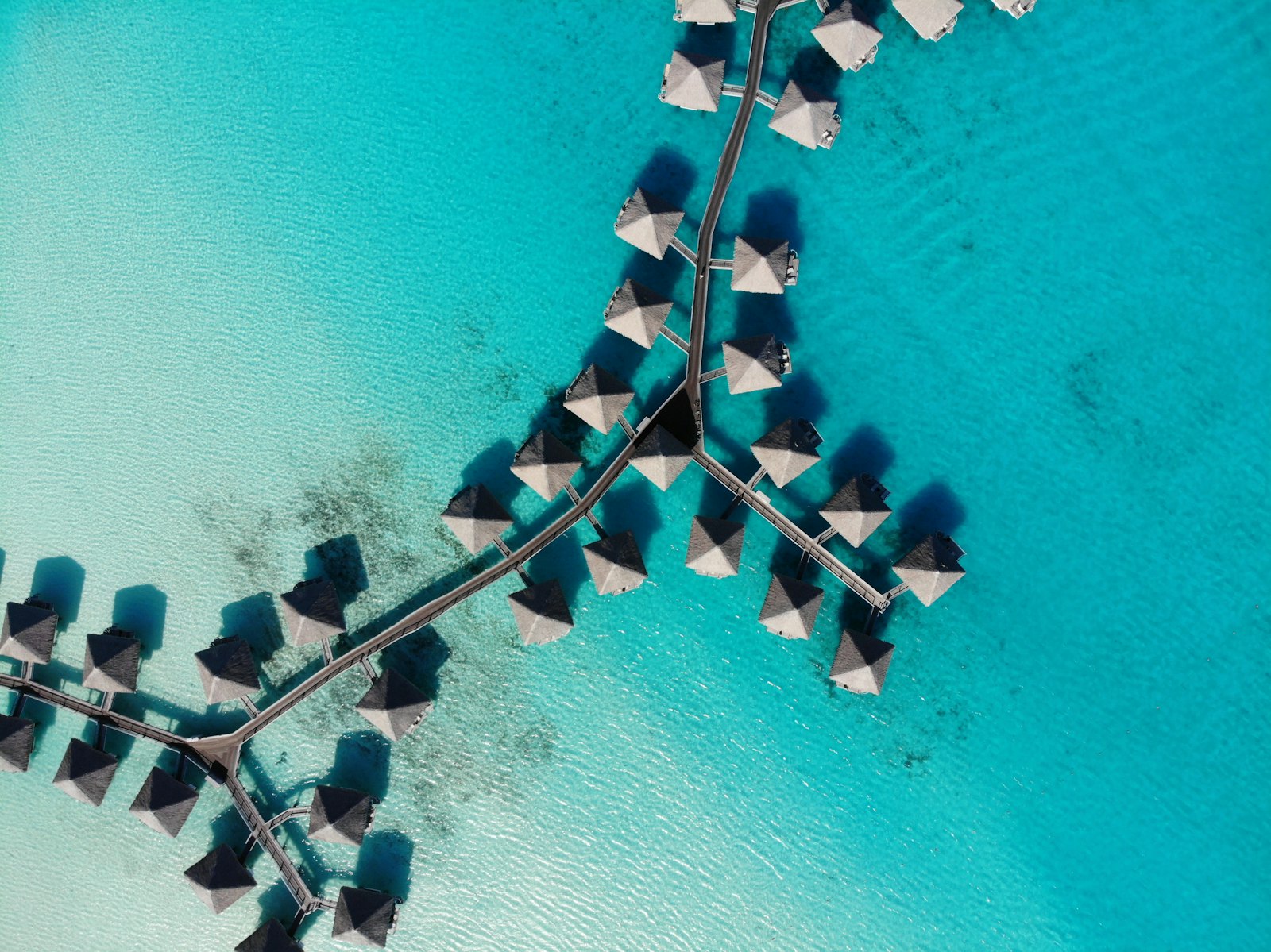 Overwater bungalows over turquoise lagoon — Bora Bora vs Maldives comparison