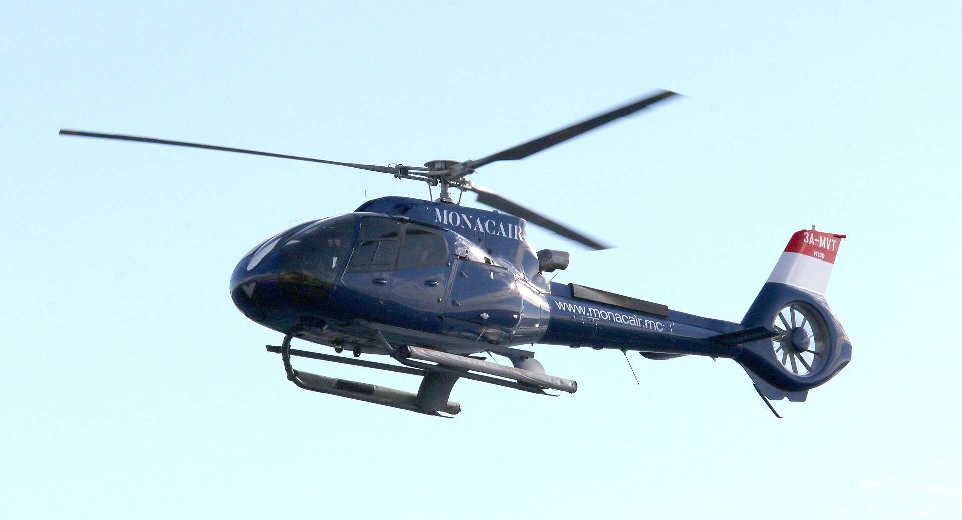 Blue Monacair Airbus H130 helicopter in flight on the Nice to Monaco shuttle