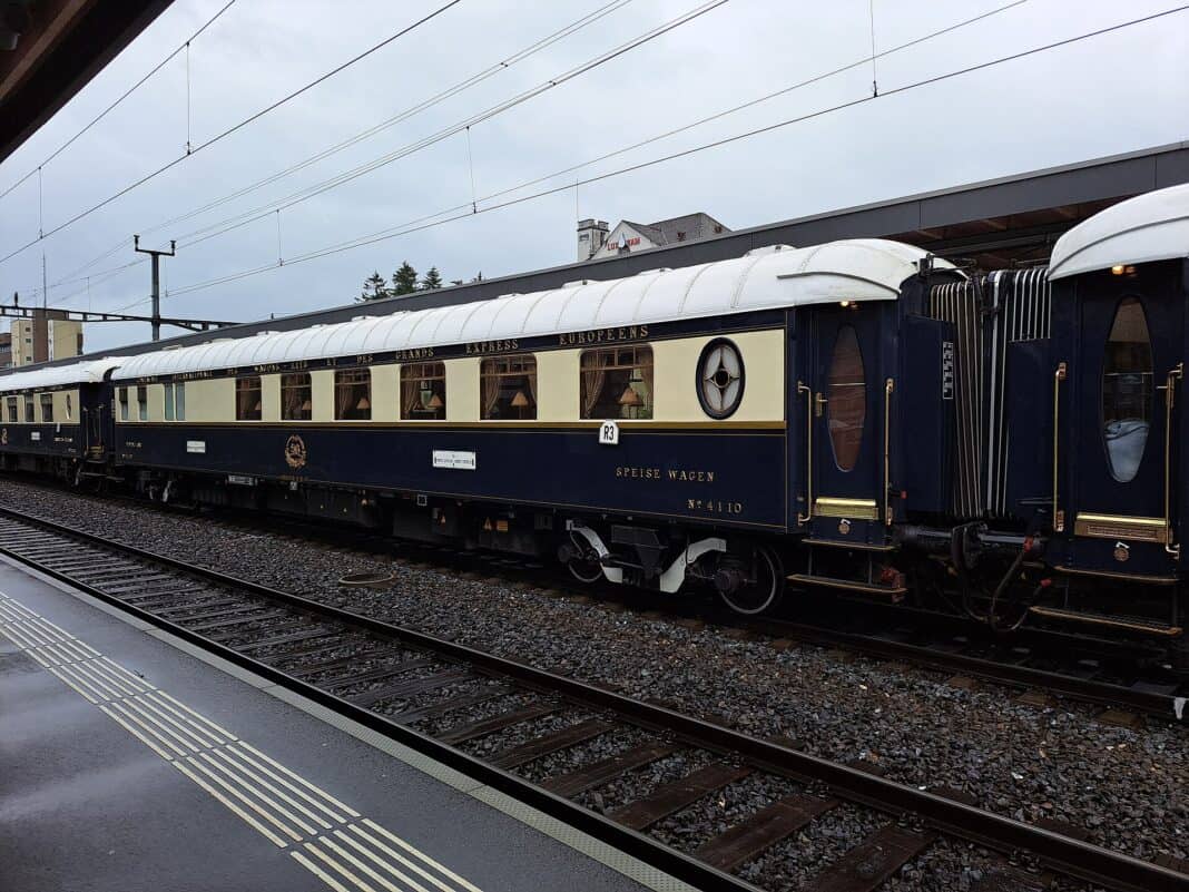 Blue and cream Venice Simplon-Orient-Express sleeping carriages at a station platform