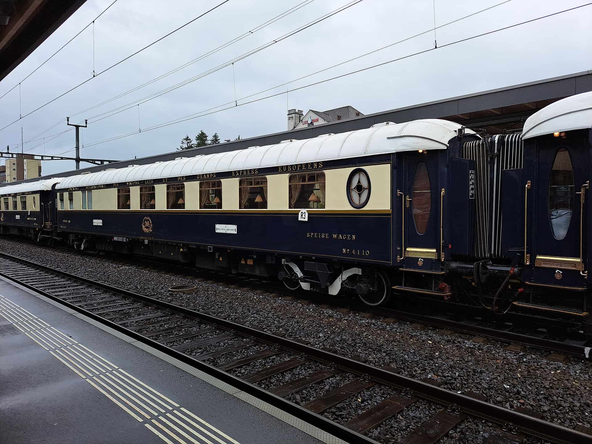 Blue and cream Venice Simplon-Orient-Express sleeping carriages at a station platform